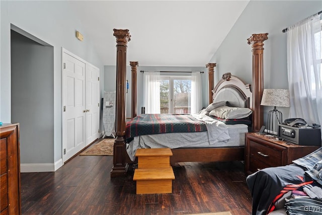 bedroom featuring dark wood-type flooring, decorative columns, and vaulted ceiling