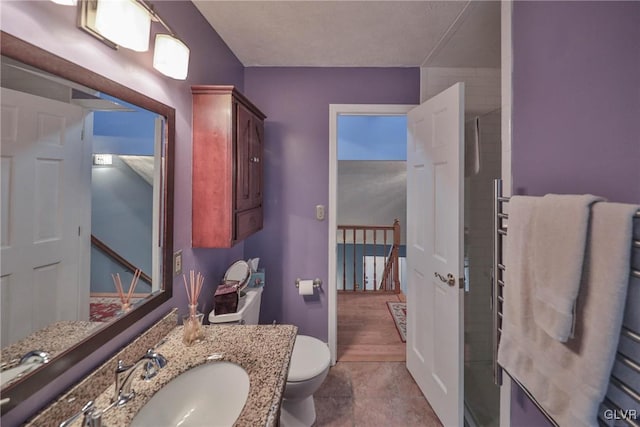 bathroom with vanity, toilet, and a shower