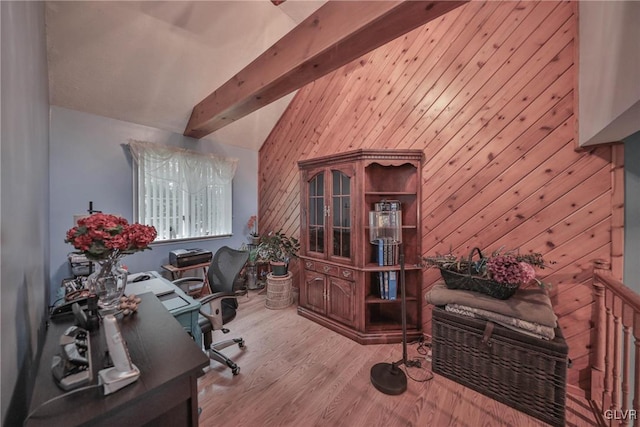 office space with wood walls, lofted ceiling with beams, and light wood-type flooring