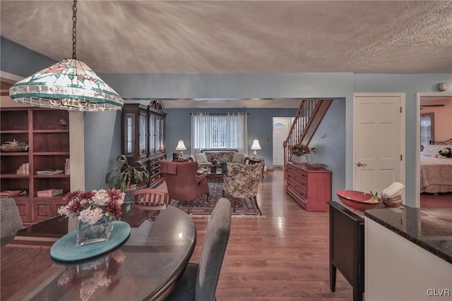 dining area with wood-type flooring and a textured ceiling