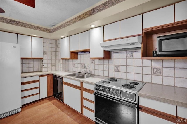 kitchen with electric range oven, white cabinetry, black dishwasher, sink, and white refrigerator