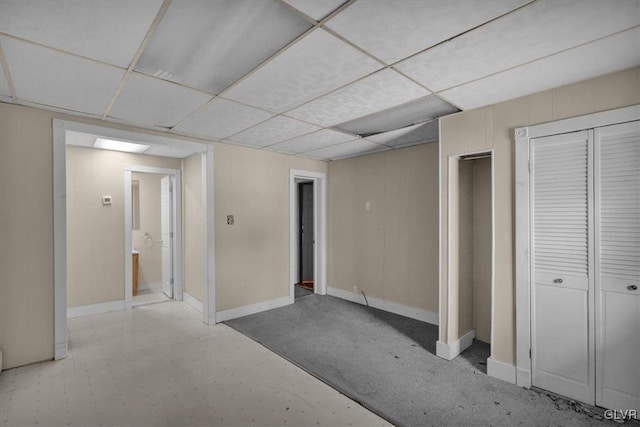 basement featuring light colored carpet and a drop ceiling