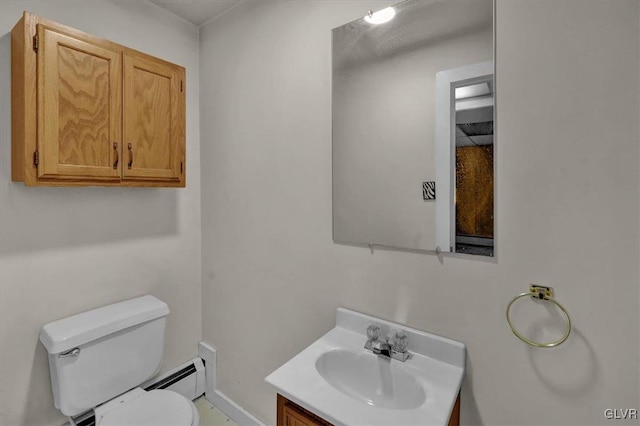 bathroom featuring vanity, a baseboard heating unit, and toilet