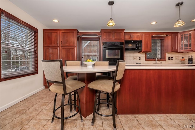 kitchen with hanging light fixtures, backsplash, and plenty of natural light