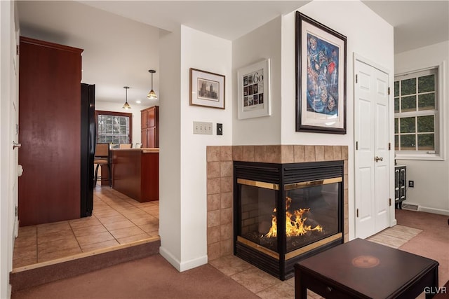 room details featuring black fridge, carpet flooring, and a tile fireplace