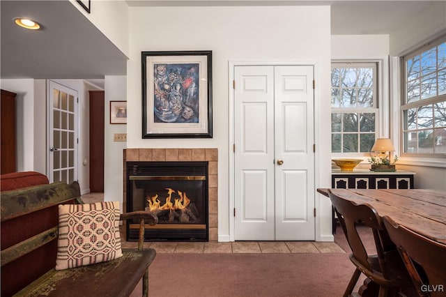 living room featuring a tiled fireplace and light carpet