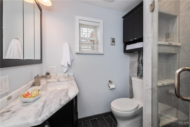 bathroom featuring vanity, an enclosed shower, and toilet