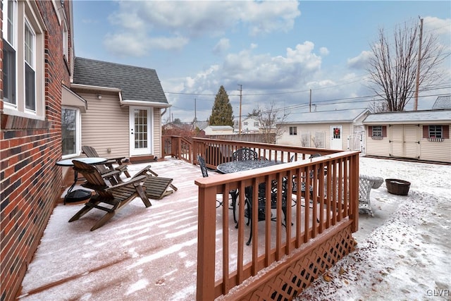 snow covered deck with a storage unit