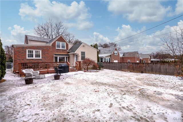 snow covered property with a wooden deck