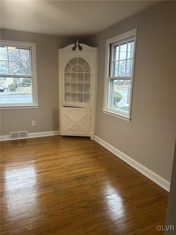 unfurnished room featuring hardwood / wood-style flooring and a wealth of natural light