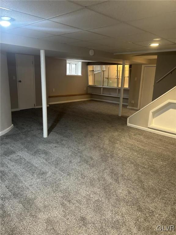 basement featuring carpet flooring and a drop ceiling