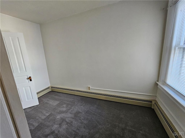 carpeted spare room with a baseboard radiator