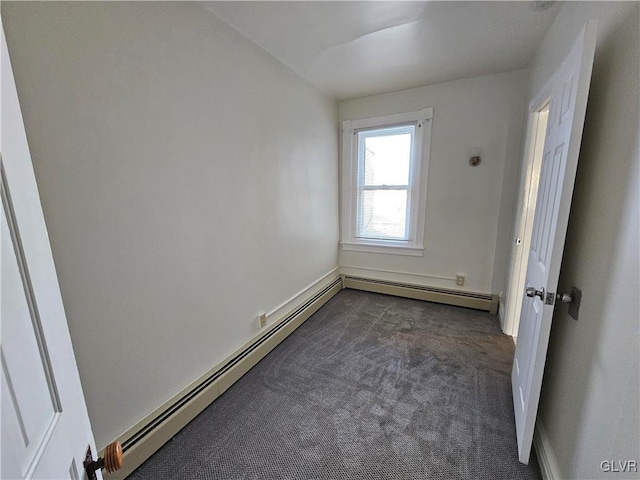 carpeted spare room with a baseboard heating unit