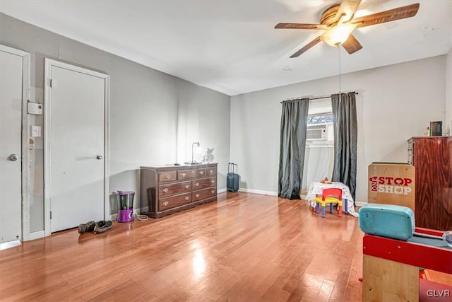 recreation room with wood-type flooring, cooling unit, and ceiling fan