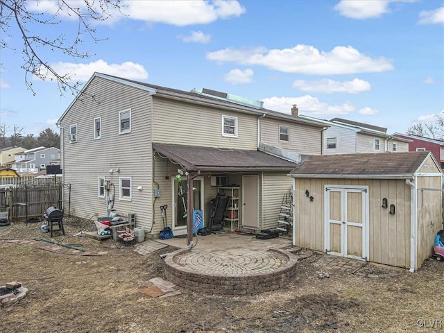 back of house with a storage shed and a wall mounted AC