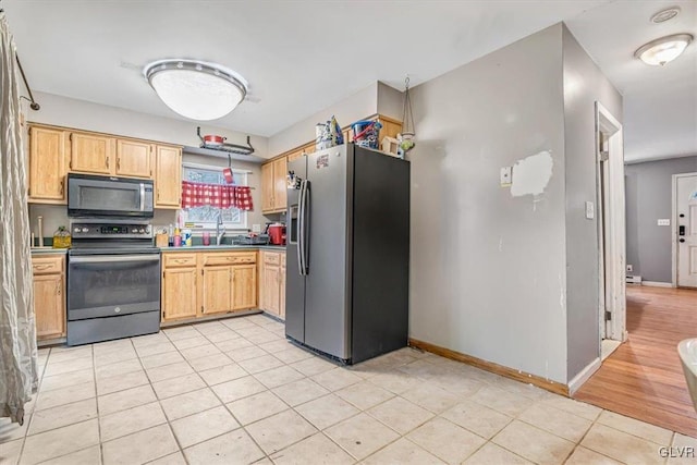 kitchen featuring light tile patterned flooring, appliances with stainless steel finishes, and sink