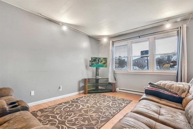 living room featuring a baseboard radiator, track lighting, and light wood-type flooring