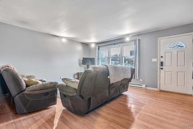 living room with baseboard heating and light wood-type flooring