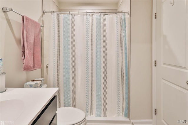 bathroom featuring vanity, toilet, and walk in shower