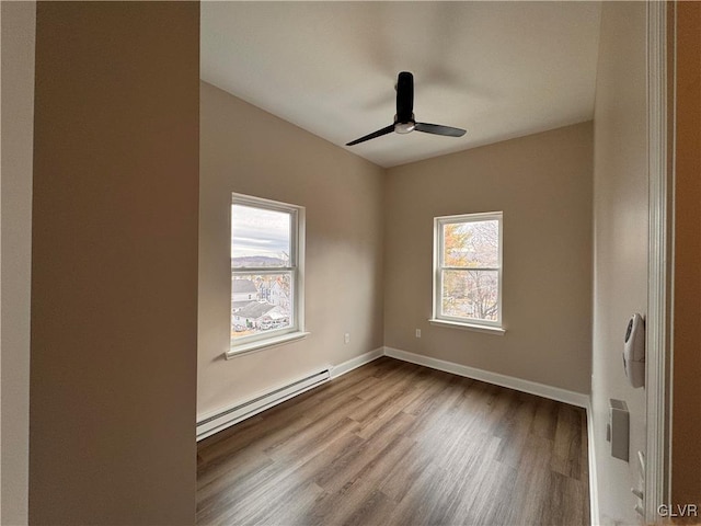 unfurnished room featuring a baseboard heating unit, ceiling fan, and light hardwood / wood-style flooring