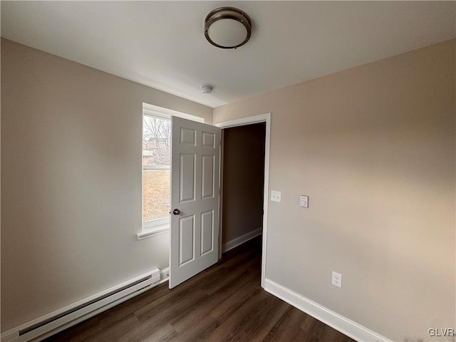 unfurnished room with a baseboard radiator and dark hardwood / wood-style flooring