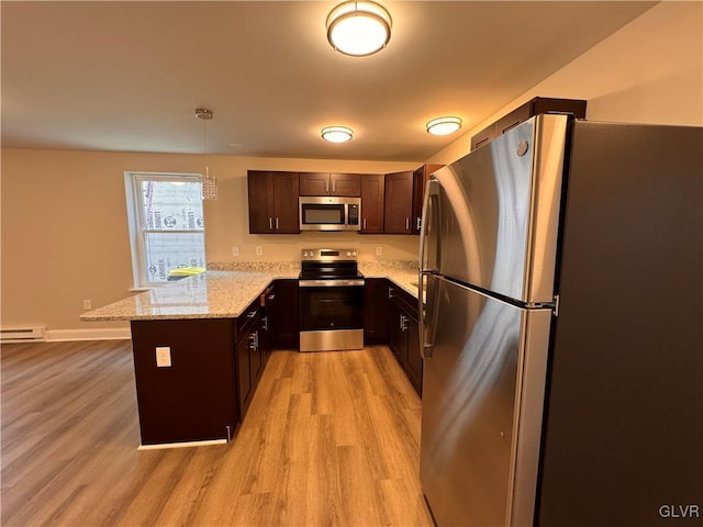 kitchen featuring light hardwood / wood-style flooring, hanging light fixtures, dark brown cabinets, stainless steel appliances, and light stone counters