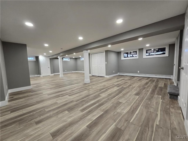 basement featuring hardwood / wood-style floors and baseboard heating