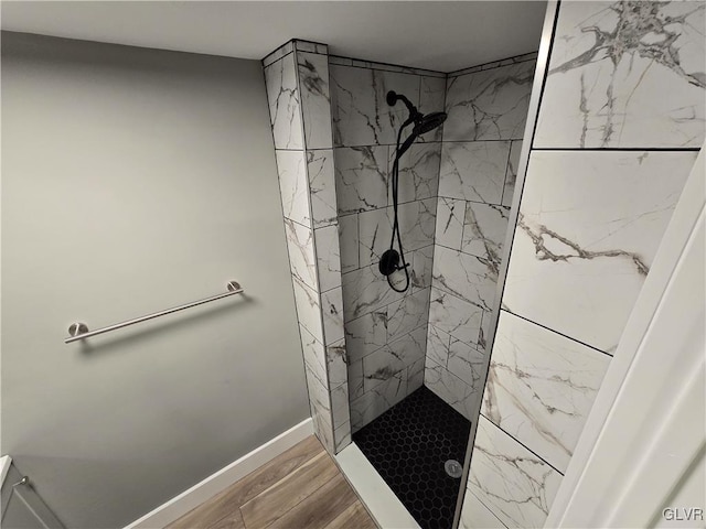 bathroom featuring a tile shower and hardwood / wood-style flooring