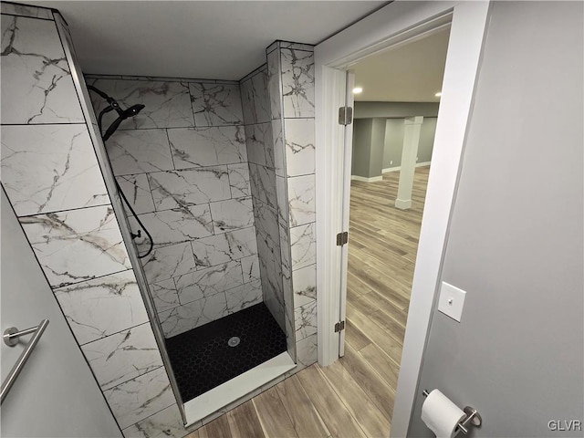 bathroom featuring wood-type flooring and tiled shower