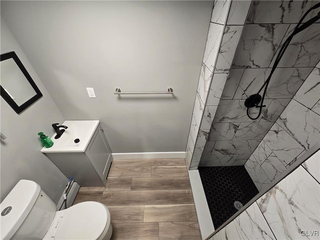 bathroom featuring tiled shower, vanity, and toilet