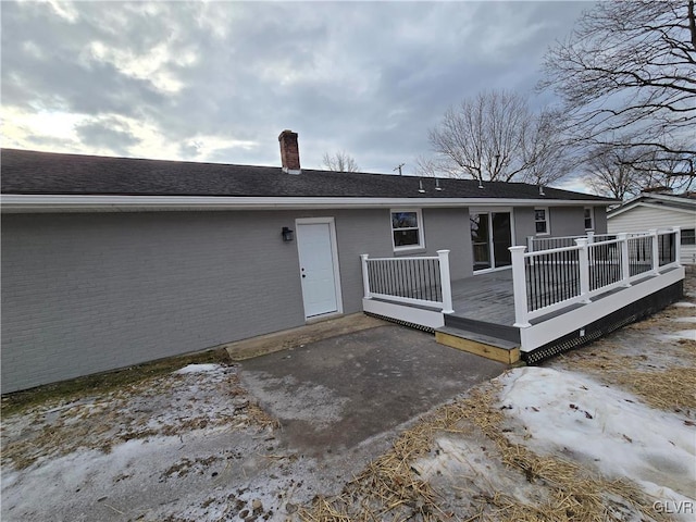 rear view of property featuring a wooden deck