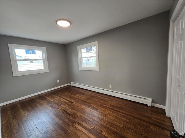 interior space with a baseboard radiator and dark hardwood / wood-style flooring