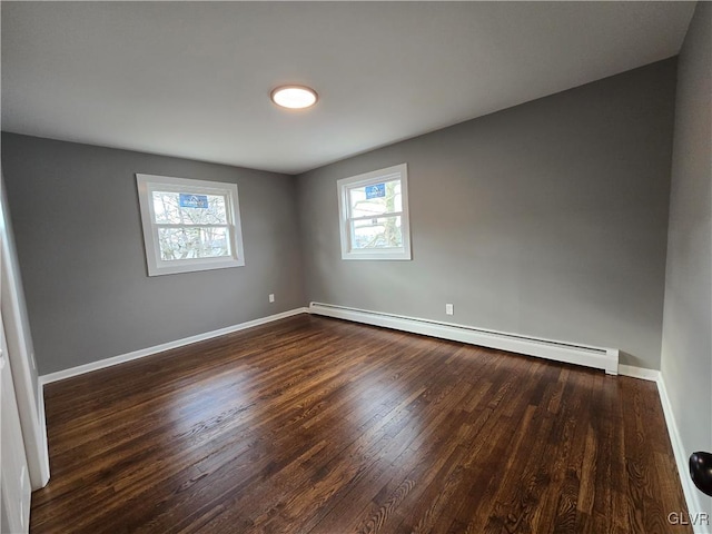 empty room featuring dark hardwood / wood-style flooring and baseboard heating