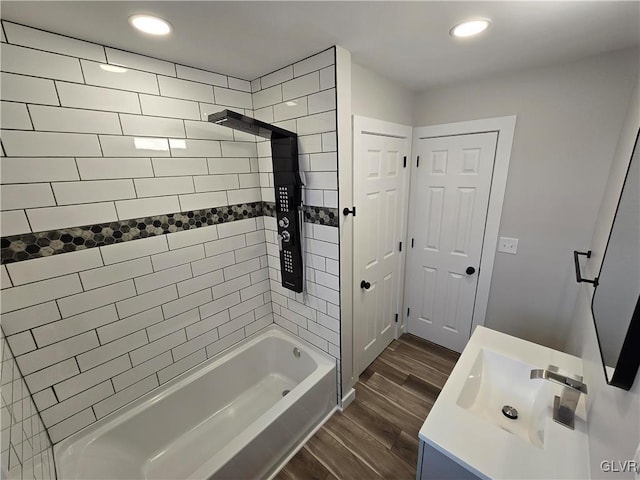 bathroom with vanity, hardwood / wood-style floors, and tiled shower / bath