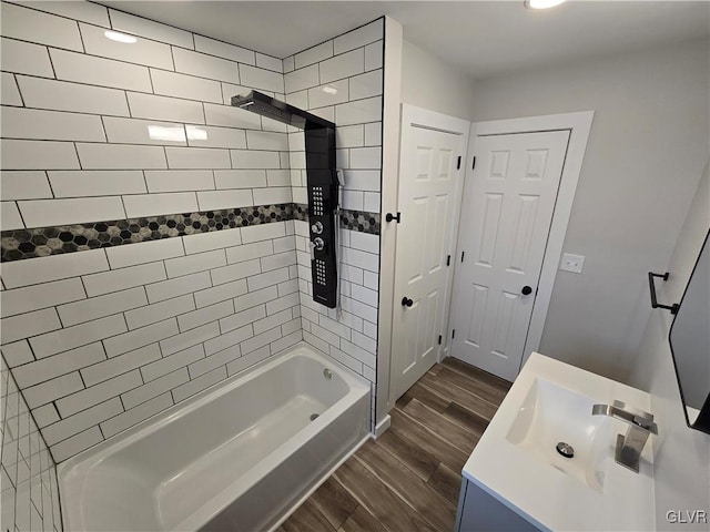 bathroom with vanity, tiled shower / bath combo, and hardwood / wood-style floors