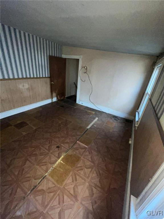 spare room featuring parquet floors and a textured ceiling