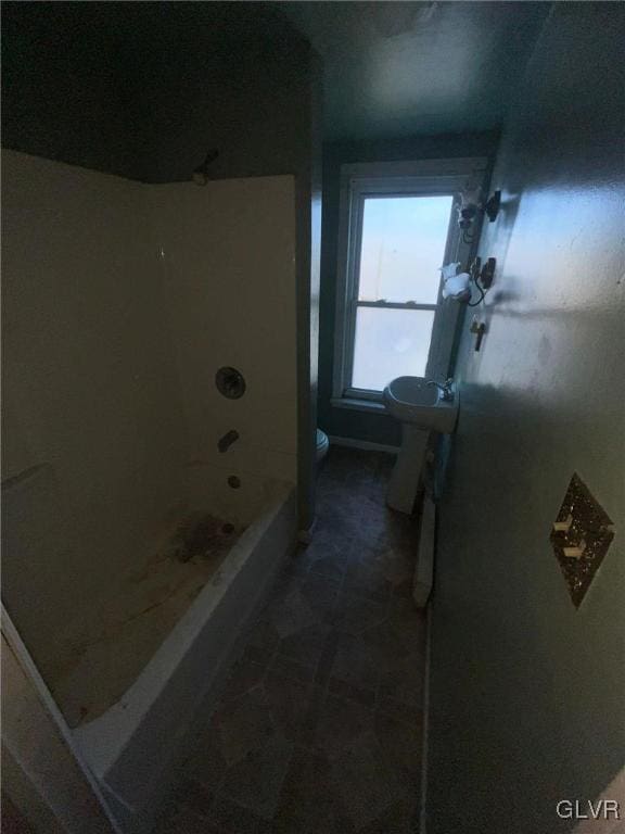 bathroom featuring shower / bathtub combination and toilet