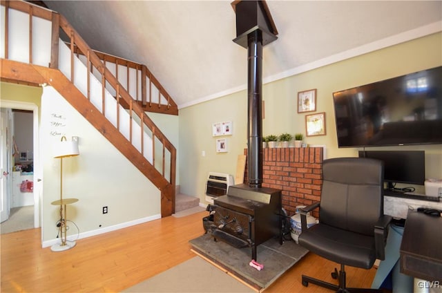 interior space featuring lofted ceiling, a wood stove, and light hardwood / wood-style floors