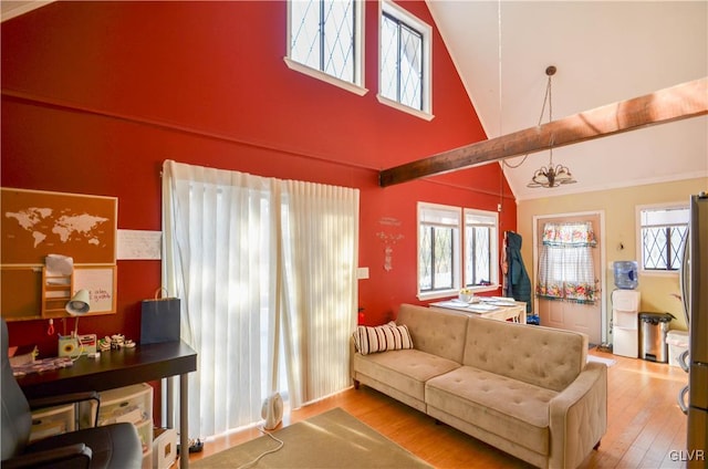 living room with high vaulted ceiling, a healthy amount of sunlight, a chandelier, and hardwood / wood-style floors