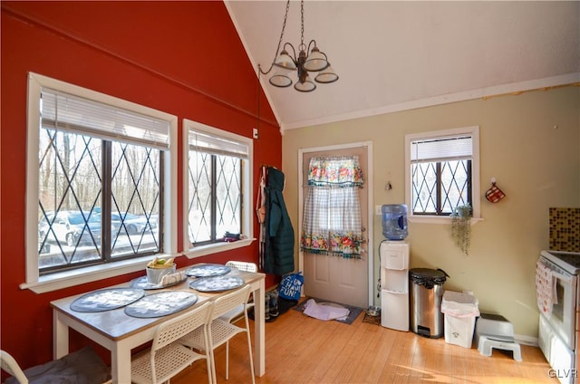 dining space featuring a notable chandelier, vaulted ceiling, and light hardwood / wood-style floors