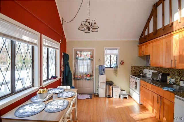 kitchen featuring lofted ceiling, a notable chandelier, white appliances, and backsplash