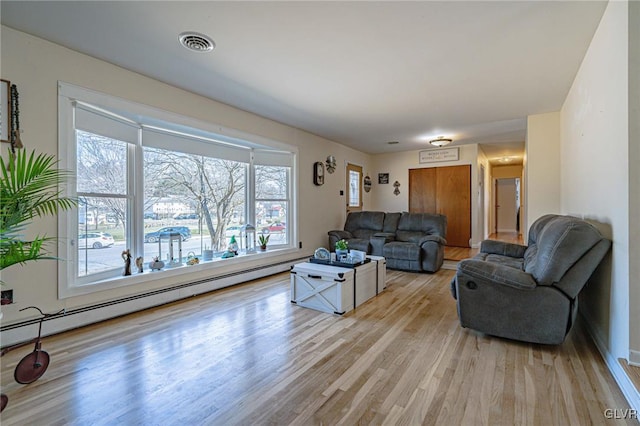 living room featuring a baseboard radiator and light wood-type flooring