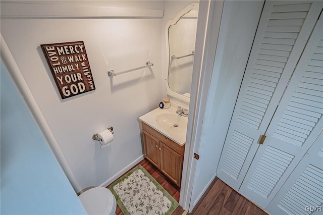 bathroom featuring vanity, hardwood / wood-style floors, and toilet