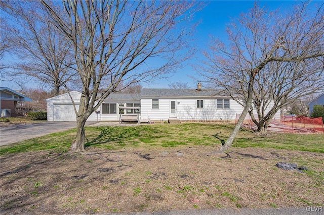 view of front of home with a garage, an outdoor structure, and a front lawn