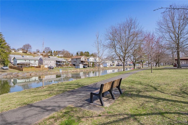 view of home's community featuring a lawn and a water view