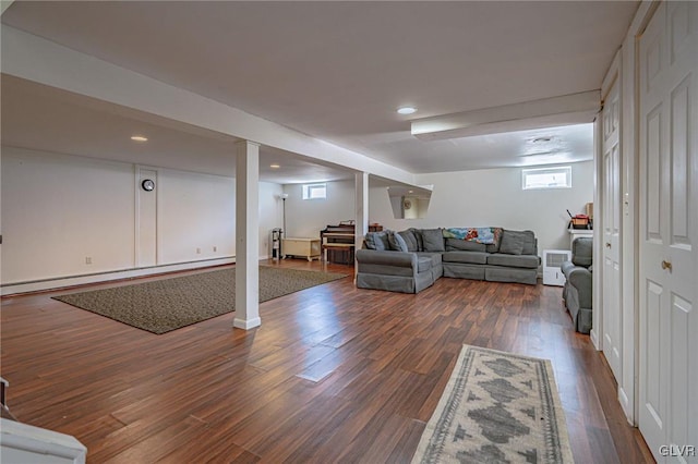 living room with a baseboard heating unit and dark wood-type flooring