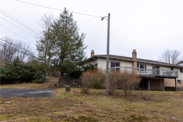 exterior space with a deck and a lawn