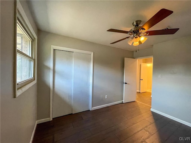 unfurnished bedroom featuring ceiling fan, dark hardwood / wood-style flooring, and a closet