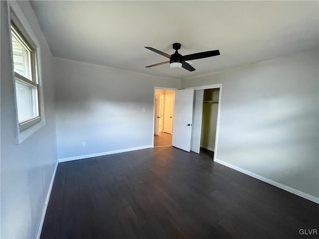 unfurnished bedroom with dark hardwood / wood-style floors, ceiling fan, and a closet