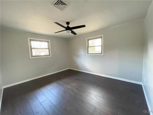 unfurnished room with dark wood-type flooring, a wealth of natural light, and ceiling fan